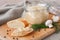 Fresh homemade mushroom pate in a jar and on a baguette slice on a rustic background, with champignons and dill