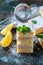 Fresh homemade sweet cake for breakfast with slices of lemon and mint on wooden board.