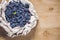 Fresh honeysuckle blue berry fruits with leaf on a wooden background