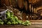 Fresh hops and wheat spikes on wooden table in beer cellar