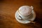 Fresh hot Coffee by top view on wooden table.cappuchino coffee in white porcellan cup and saucer with silver spoon