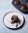 Fresh hot vegan chocolate fondant lava with  berries   on a white plate on a blue-gray background