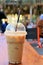 Fresh ice coffee in plastic cup on wood table in the cafeteria