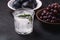 Fresh ice cold carbonated water in glass with rosemary leaf near to wooden bowls with grape and plum fruits