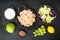 Fresh ingredients for tasty Waldorf prawn salad, with sauce apple and grape, on black stone background, top view flat lay