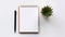 A fresh and inviting image of a blank notepad with a pen and a succulent plant on a white background. The notepad is