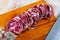 Fresh italian piacenza salami cut in slices on a wooden surface