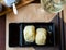 Fresh Japanese triangular onigiri with rice at black plate