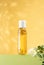 Fresh jasmine flowers inside a bottle of jasmine essential oil standing on a light green podium. Cosmetic oil for body baths on an