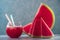 Fresh juice of sweet spanish watermelon in glass with straws and just cutted slices on blue background. Close up shot with