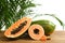 Fresh juicy cut papayas on wooden table against blurred background