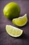 Fresh juicy limes on dark canvas background