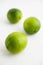 Fresh juicy limes on white wooden background