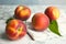 Fresh juicy peaches, leaves and fabric on table