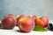 Fresh juicy peaches, leaves and fabric on white table