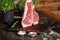 Fresh, juicy seasoned t-bone steak in a standing position on a grill pan with a hunting knife next to it, in the restaurant