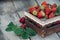 Fresh juicy strawberries with leaves. Rustic wooden box and handmade lace. Retro magazine picture. Strawberry with copy space