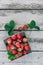 Fresh juicy strawberries with leaves. Rustic wooden box and handmade lace. Retro magazine picture. Strawberry with copy space