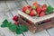 Fresh juicy strawberries with leaves. Rustic wooden box and handmade lace. Retro magazine picture. Strawberry with copy space