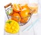 Fresh juicy summer fruits, oranges, mango, kiwi in a vintage basket and refreshment drinks on a wooden table on a white background