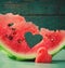 Fresh juicy watermelon heart at turquoise wooden background. Saint Valentine, love greeting card