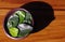 Fresh kaffir lime leaves on a clay dish and its shadow on the wood table