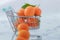 Fresh kumquat orange fruit in supermarket shopping chart. healthy life style. marble backgroun.dramatic scene