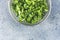 Fresh lambs lettuce or corn salad leaves in metal sieve on light grey table surface. Top view, copy space