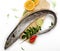 Fresh Largehead hairtail fish,Belt fish decorated with herbs and vegetables on a wooden pad.Selective focus