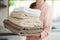 Fresh laundry. Shot of a young woman carrying a pile of folded towels.