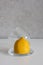 Fresh lemon in a glass mini dome lemon keeper on white table