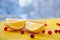 Fresh lemon slices with red berries on the wooden table with free blurred copy space. Ingredients for healthy juice or detox drink