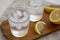 Fresh Lemon Sparkling Water with Ice on a rustic wooden board, side view. Close-up