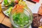 Fresh lemonade with lime and ice cubes in a sugar rimmed glass on wood with limes in back on black background Very