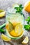 Fresh lemonade with mint, lemon and ice in glass jar on wooden background. Summer drinks and cocktails