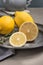 Fresh lemons and lemons leaves on rustic plate. Fresh citrus fruit background