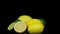 Fresh lemons and limes rotating in a circle, black background, and space for text.