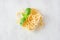 Fresh linguine pasta with basil, top view against white marble