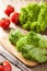 Fresh lollo leaves and tomatoes on chopping board for salad