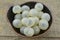 Fresh longan in black bowl on wooden table