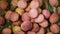 Fresh lychee fruits on rotating background. Top view. Exotic fruits, tropical palm branch. Vegan and raw food concept.