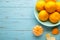 Fresh mandarin oranges fruit on mint bowl on blue wooden background