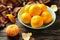 Fresh mandarin oranges fruit on mint bowl on brown wooden background