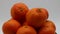 Fresh mandarin oranges fruit on rotating display isolated on white background