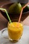 Fresh mango smoothie with two straws
