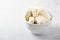 Fresh mascarpone cheese in a white bowl for making Italian tiramisu dessert on light background.