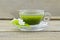 Fresh matcha tea with jasmine in cup on wooden table