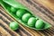 Fresh mature pod of green peas on the old wooden background