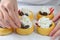 Fresh mini biscuit cups filled with berries and cream. Homemade dessert, woman hands