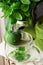 Fresh mint bunch in tin can, glass cup, pot, lime on linen cloth, preparing to brew herbal tea